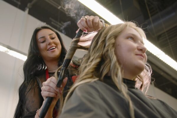 Hair stylist curling a client’s hair in a salon